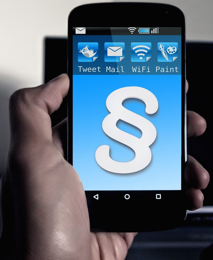 迅雷电影 App 主界面展示，深色背景中一部手机屏幕亮着，影片封面整齐排成两列网格，顶部搜索框静候输入